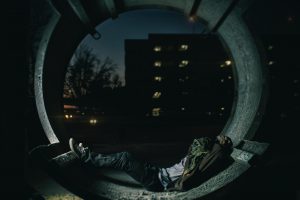Man sitting in tunnel at night