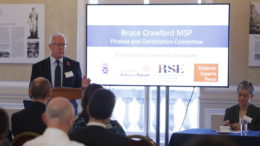 Image of Convener Bruce Crawford MSP standing in front of his presentation at Post Brexit Common Frameworks - 2 Nov 2018