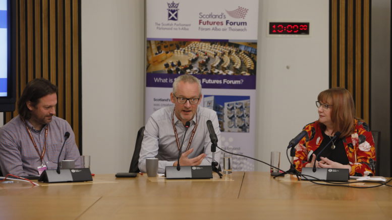Tom Chivers speaks at the Scottish Parliament, next to Chris Deerin from Reform Scotland and Clare Adamson MSP, chair of the event