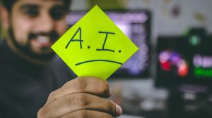 Man holding post-it with AI written on it