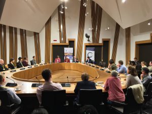 Photo of event with people sitting around a committee room table in the Scottish Parliament