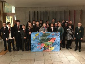 School pupils holding painted map of Scotland with UN Convention on the Rights of the Child inscribed on it
