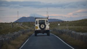 Range-rover driving into distance toward mountain