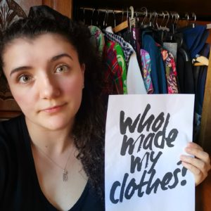 Iona Whyte holding a sign "Why made my clothes?"