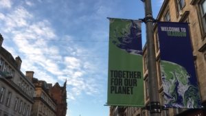 COP26 banner hanging in Glasgow against blue sky