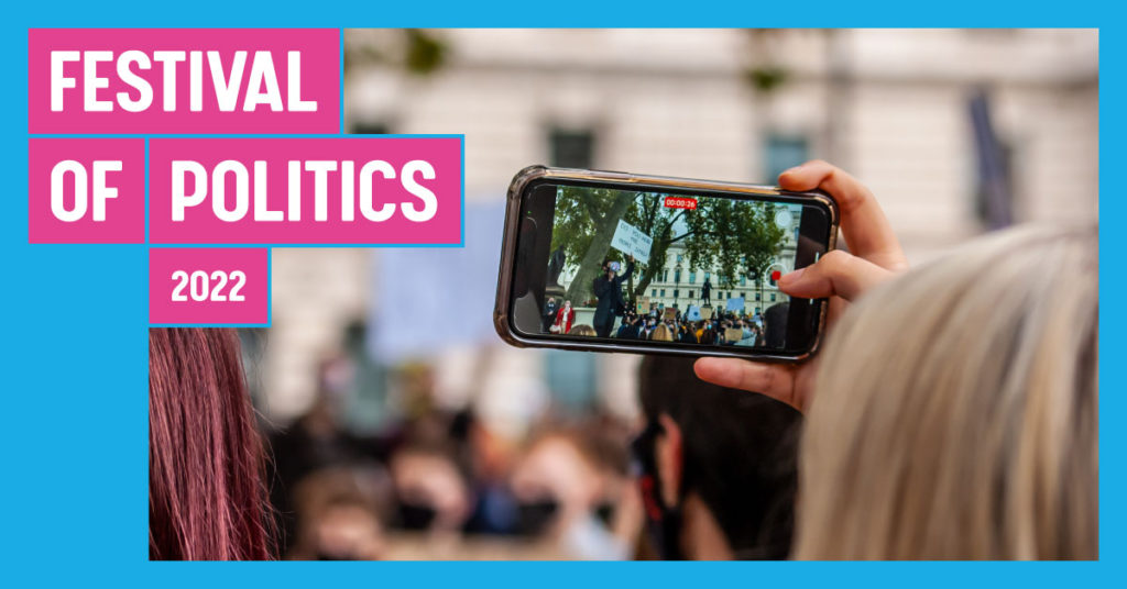 Festival of Politics banner with person recording demonstration on their phone