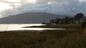 Scottish landscape with loch mountain and cloudy sky