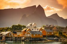 A Scandinavian village with tall mountains behind